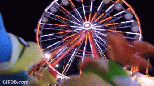 A Ferris Wheel At An Amusement Park At Night With A Circle In The Middle GIF