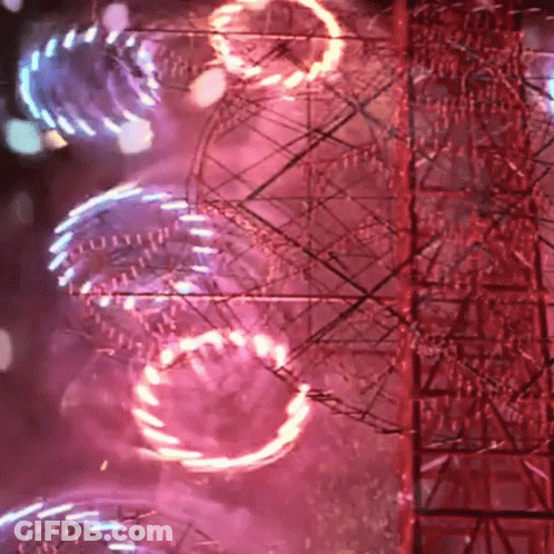 A Ferris Wheel Is Lit Up At Night With A Red Background GIF