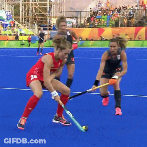 A Field Hockey Player Wearing A Red Uniform With The Number 74 On It GIF