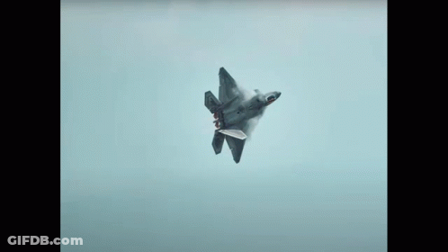 A Fighter Jet Is Flying Through A Clear Blue Sky GIF