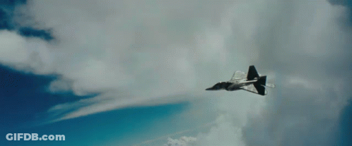 A Fighter Jet Is Flying Through A Cloudy Blue Sky With Chinese Writing On The Bottom Right Corner GIF