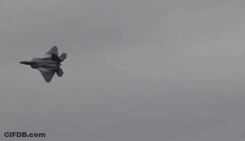A Fighter Jet Is Flying Through A Cloudy Sky In Slow Motion . GIF