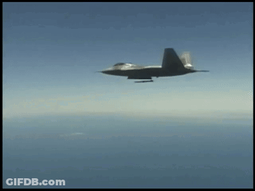 A Fighter Jet Is Flying Through The Air With A Missile Attached To It GIF