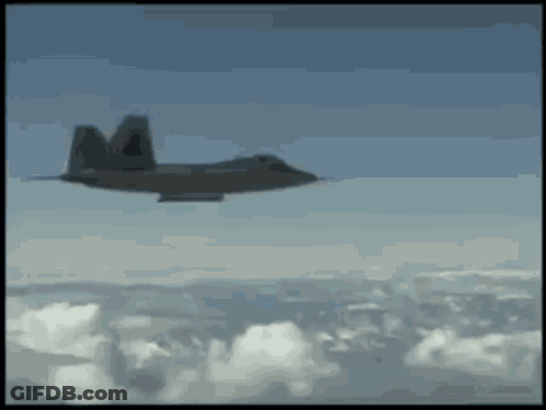 A Fighter Jet Is Flying Through The Clouds With The Letter M On The Tail GIF