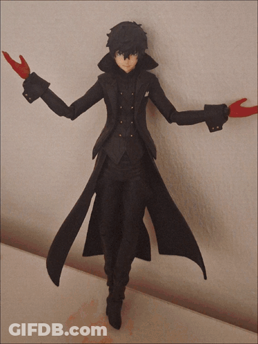 A Figurine Of A Man In A Black Coat With Red Gloves Is Standing On A Table GIF