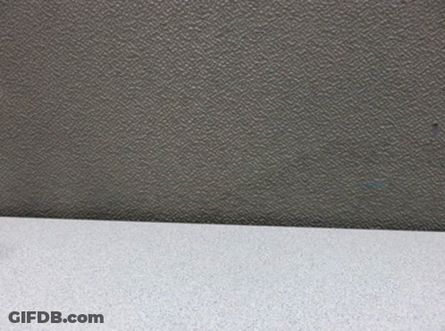 A Figurine Of A Man In A Suit And Hat Is Standing On A Table GIF