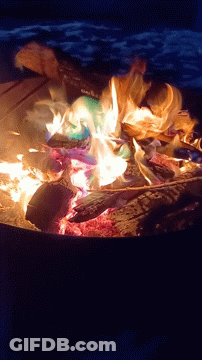 A Fire Is Being Lit With A Can Of Coca Cola In It GIF