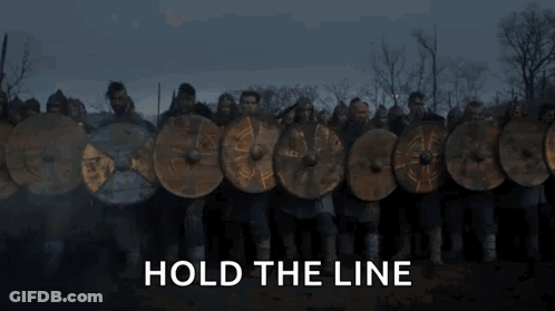 A Fire Is Burning In A Field With The Words `` Hold The Line '' Above It . GIF