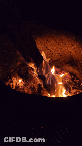 A Fire Is Burning In A Metal Container With Holes In It GIF