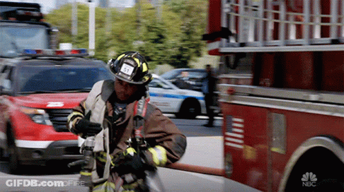 A Fireman In Front Of A Nbc Fire Truck With #Chicagofire Written On The Bottom GIF