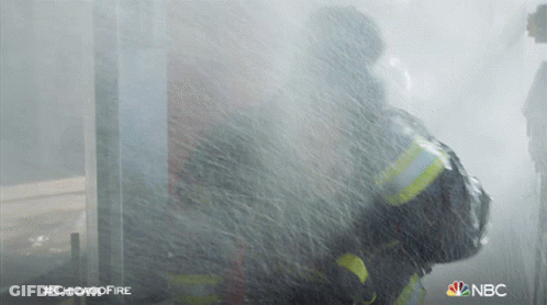 A Fireman Is Spraying Water From A Hose With The Hashtag #Chicagofire On The Bottom GIF