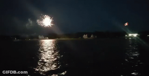 A Firework Display Over A Body Of Water GIF