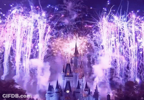 A Fireworks Display Over A Castle With A Clock On The Tower GIF