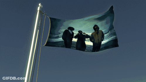 A Flag With A Picture Of Three People On It Is Waving In The Wind GIF