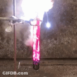 A Flame Is Coming Out Of A Test Tube Filled With Red Liquid GIF