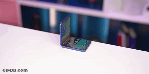 A Folding Phone Is Sitting On A White Table GIF