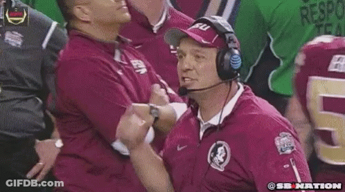 A Football Coach Wearing Headphones Is Giving A Thumbs Up To His Team GIF