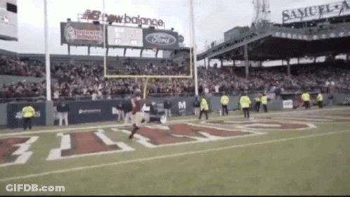 A Football Game Is Being Played In A Stadium Sponsored By Samuel Adams GIF