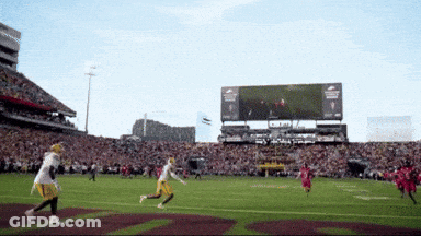 A Football Game Is Being Played In A Stadium With A Scoreboard That Says Ram GIF