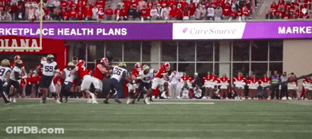 A Football Game Is Being Played In Front Of A Banner That Says Caresource GIF