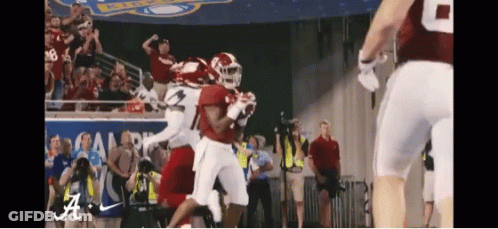 A Football Game Is Being Played In Front Of A Crowd With The Letters A On The Banner GIF