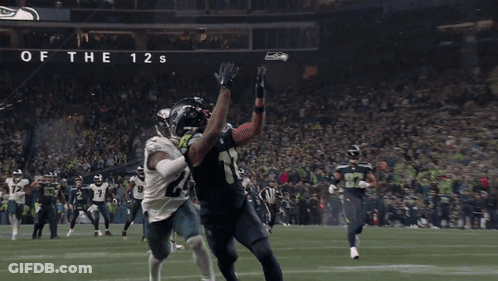A Football Game Is Being Played In Front Of A Sign That Says Home Of The 12S GIF