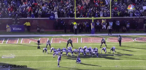 A Football Game Is Being Played On A Field With A Banner That Says Verizon In The Background GIF