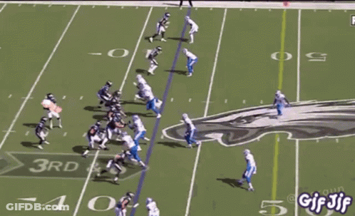 A Football Game Is Being Played On A Field With A Bunch Of People Watching . GIF