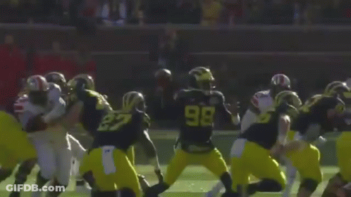 A Football Game Is Being Played On A Field With A Crowd Watching GIF