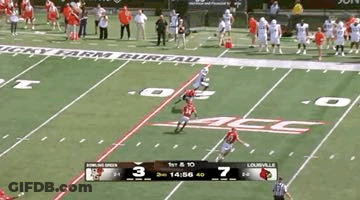 A Football Game Is Being Played On A Field With A Scoreboard Showing The Score . GIF