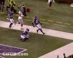 A Football Game Is Being Played On A Field With Players Running Down The Field . GIF