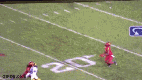 A Football Game Is Being Played On A Television Screen With A Blurred Image Of A Football Field . GIF