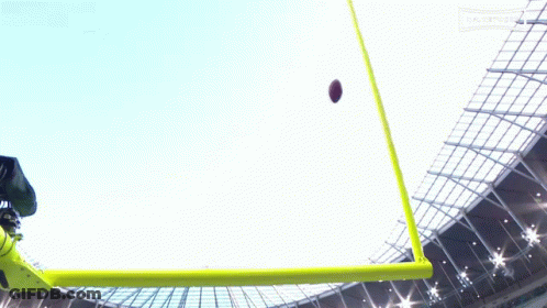 A Football Is Being Kicked Into The Air By A Referee GIF