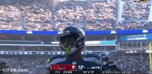 A Football Player Celebrates A Touchdown During A Game GIF