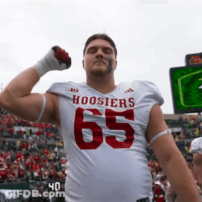 A Football Player For The Hoosier 'S Is Flexing His Muscles GIF