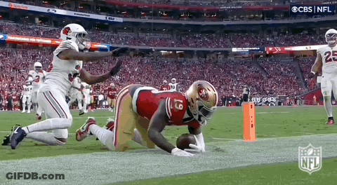 A Football Player In A 49Ers Uniform Is Kneeling On The Field . GIF