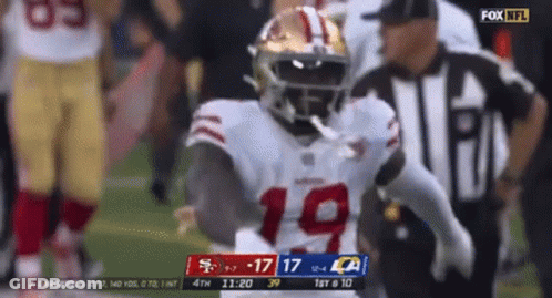 A Football Player In A 49Ers Uniform Is Running On The Field GIF