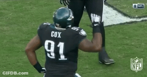 A Football Player In A Black Uniform Is Running On The Field . GIF