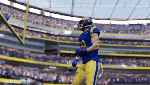 A Football Player In A Blue And Yellow Uniform With The Number 30 On His Jersey GIF