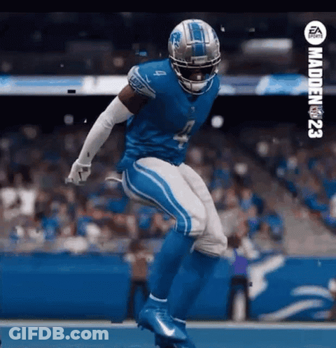 A Football Player In A Detroit Lions Uniform Is Jumping In The Air On A Field . GIF