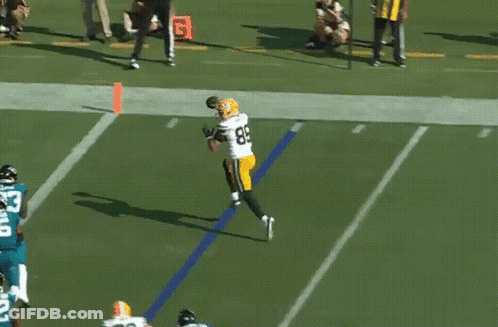 A Football Player In A Green Bay Packers Uniform Catches A Ball GIF