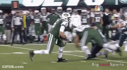 A Football Player In A Jets Uniform Is Running On The Field . GIF