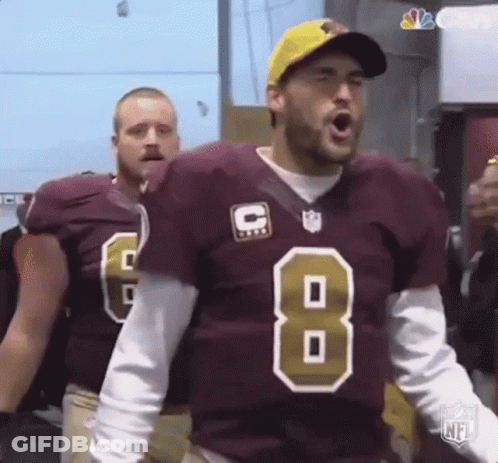 A Football Player In A Maroon Jersey With The Number 8 On It Is Standing In A Locker Room . GIF