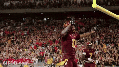A Football Player In A Maroon Uniform With The Number 8 On His Jersey GIF