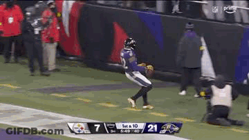 A Football Player In A Purple Uniform Is Running On A Field . GIF