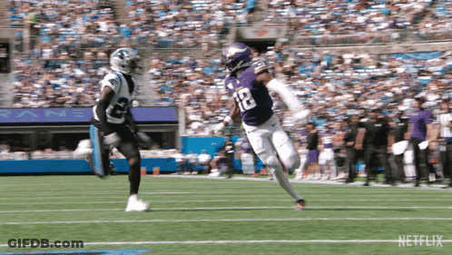 A Football Player In A Purple Uniform With The Number 12 On It GIF