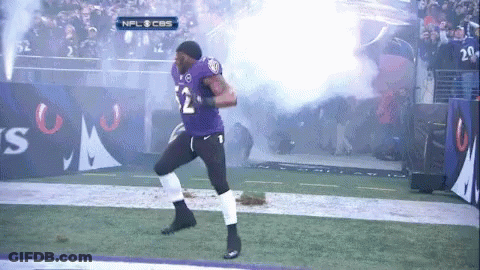 A Football Player In A Purple Uniform With The Number 12 On It GIF