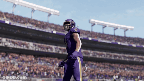 A Football Player In A Purple Uniform With The Number 18 On His Helmet GIF