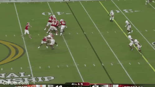 A Football Player In A Red Indiana Jersey Is Being Tackled By Another Player GIF