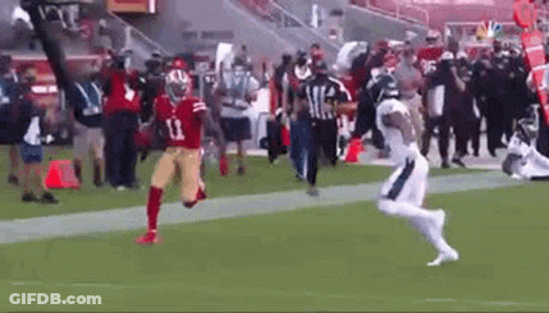 A Football Player In A Red Jersey Is Running On A Field . GIF